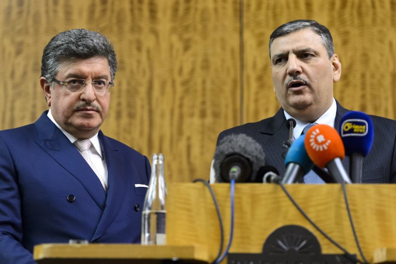 Syrian opposition chief Riad Hijab, right, standing next to High Negotiations Committee (HNC) spokesman Salem al-Meslet, left, as they attend a press conference after Syrian peace talks, at the President Wilson hotel in Geneva, Switzerland, Feb 3, 2016. (Martial Trezzini / Keystone via AP)