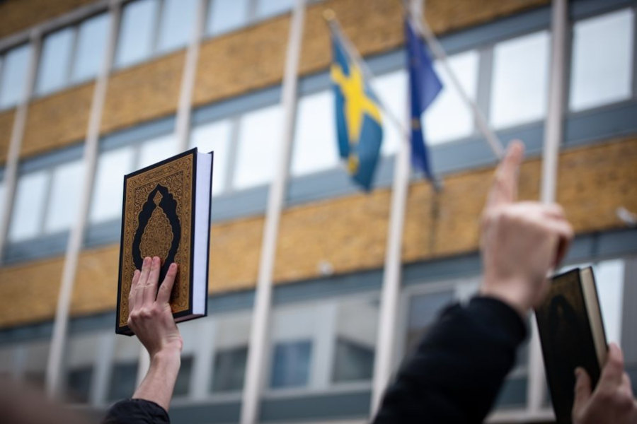 Коран на фоне посольства Швеции