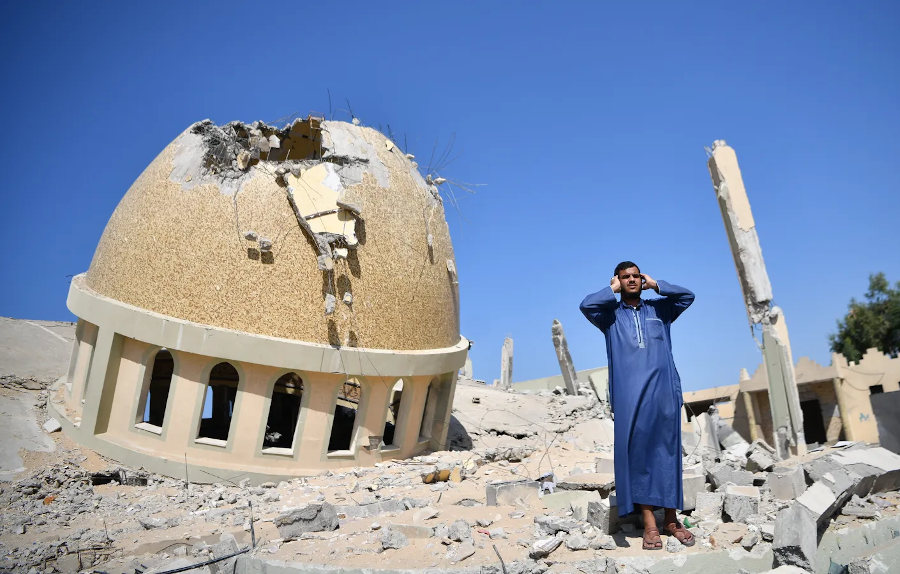 Палестинец призывает к молитве (азан) среди развалин мечети Аль-Амин Мухаммад, пострадавшей от израильского авиаудара, в Хан-Юнисе, Газа. Фото: Абед Загут/Анадолу через Getty Images